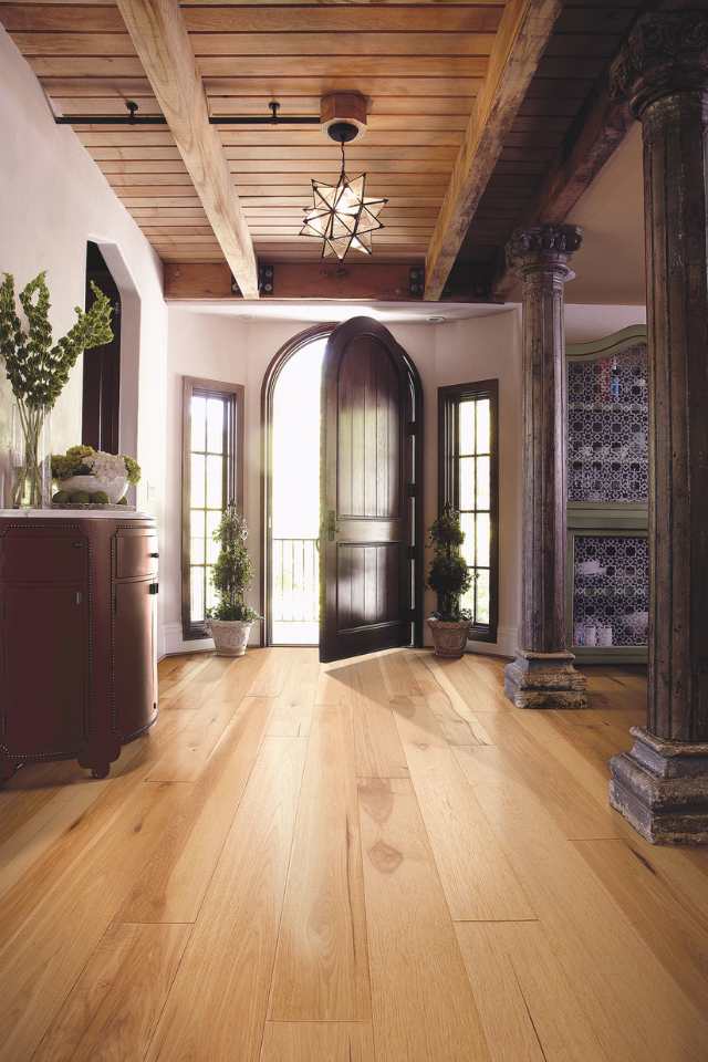 hickory hardwood in entryway of vintage revival home with statement lighting and wood beams